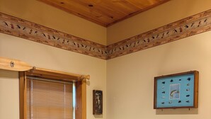 A bedroom with a bed, a window with blinds, a framed picture on the wall, and a towel on the bed. - Stay In Ohiopyle, Hot tub & Pool Table - Closest to the GAP trail (Ohiopyle)