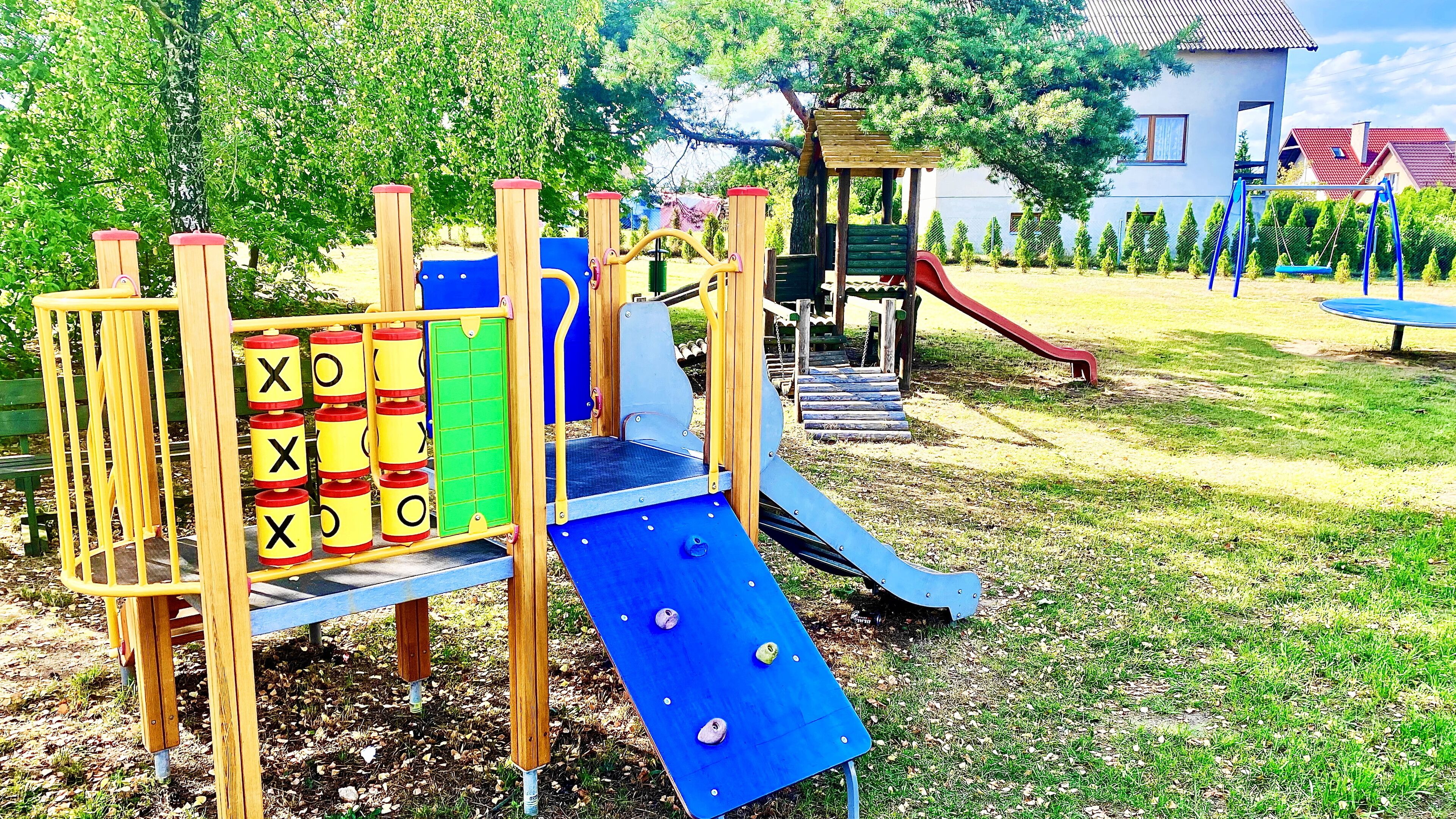 A playground with a slide, climbing structures, and a swing set.