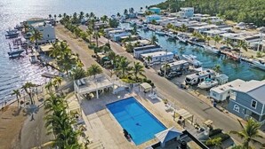 A marina with boats, RVs, and mobile homes. There is a pool and palm trees. - Amazing Sunsets, Bay Breezes in the beautiful Florida Keys (Key Largo)