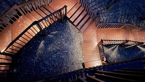 Eine Wendeltreppe mit Holzgeländern, die zu einer erhöhten Ebene führt.
