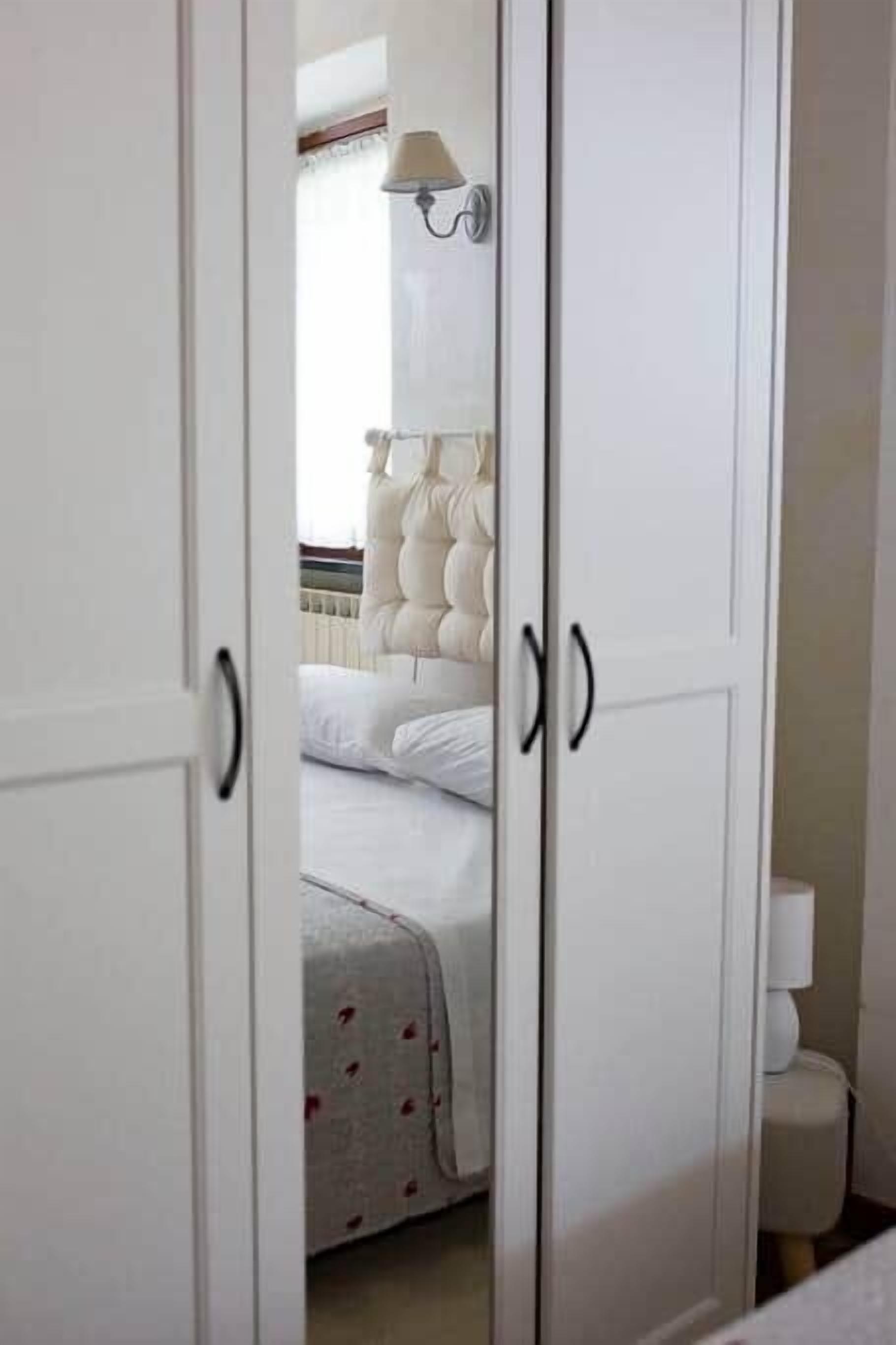 Ein Schlafzimmer mit einem Bett, einem Kleiderschrank und einem Nachttisch.