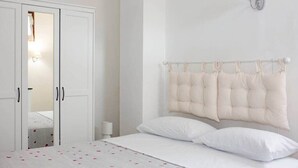 A bedroom with a bed, white curtains, a wall-mounted lamp, and a wardrobe. - Holiday Home Tra Le Mura "Timo"-Levanto 5 Terre- (Chiesa Nuova, Levanto)