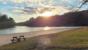 A lakeside view with a picnic table and a volleyball net. - Cutest place ever! Fun Airline decor will make you smile! Huge deck! (Jasper)