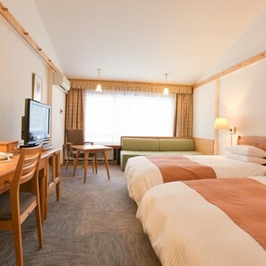 A hotel room with a bed, a desk with a television, a seating area, and a window with curtains. - Sahoro Resort Hotel (Shintoku)