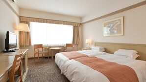 A hotel room with two beds, a desk with a computer, a chair, a small table, and a window with curtains. - Sahoro Resort Hotel (Shintoku)