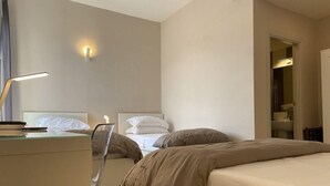 A hotel room with a bed, bedside tables, a desk, and a lamp. - Up Hotel (Naples)