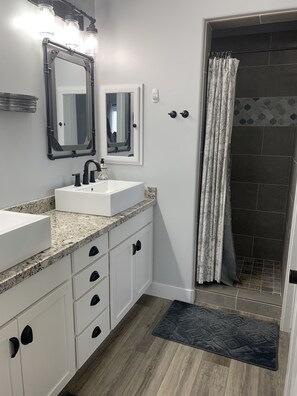 Een bad/douchecombinatie, handdoeken, zeep, shampoo