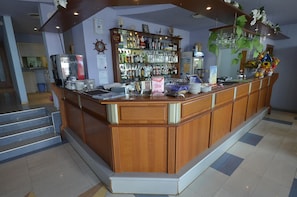 A bar area with a wooden counter, a coffee machine, and a variety of bottles. - Evridika (Nessebar)