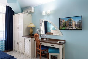 A hotel room with a desk, chair, wardrobe, mirror, and a framed picture on the wall. - Evridika (Nessebar)