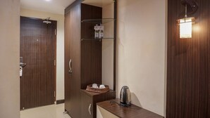 Une salle de bain moderne avec un meuble-lavabo en bois, une bouilloire et une étagère contenant des articles de toilette.
