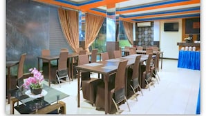 Une salle de conférence avec des tables et des chaises, une nappe bleue et un plafond décoratif.