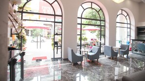A lobby with arched windows, marble flooring, and modern seating. - Fide Hotel (Ho Chi Minh Municipality)