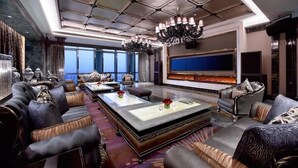 A luxurious living room with a large flat-screen TV, a fireplace, and a chandelier. - Wanda Vista Zhengzhou (Zhengzhou)