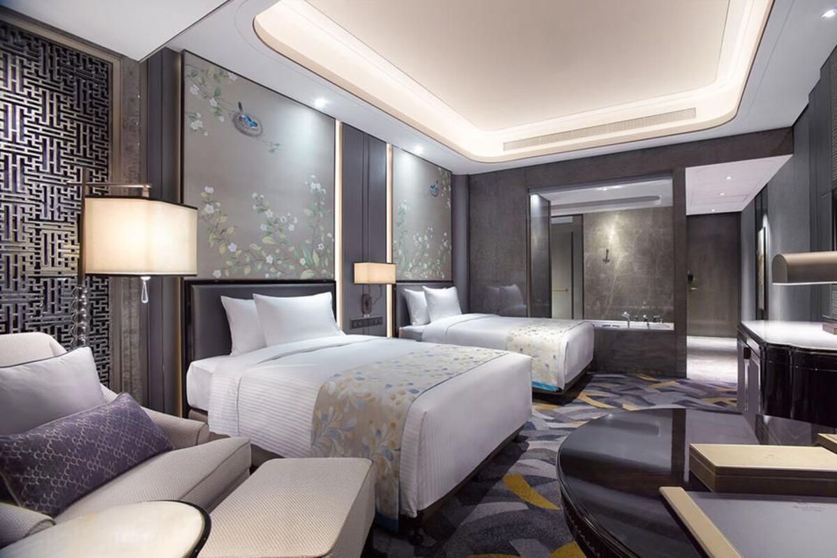 Une chambre d’hôtel moderne avec deux lits, un bureau et une salle de bain.