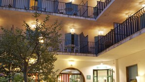 A hotel courtyard with stone flooring, outdoor seating, and potted plants. - Bell Repos (Castell-Platja d'Aro)