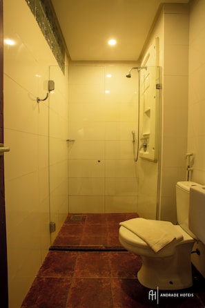 A bathroom with a glass-enclosed shower, a toilet, and a tiled floor. - Rede Andrade Docas (Belém)