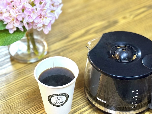 A coffee maker with a cup of coffee on a wooden table. - Nostalgia Hotel (Beijing Confucius Temple and Imperial College Museum & Gui Street) (Beijing)