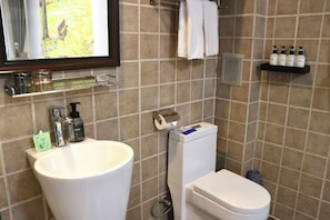 A bathroom with a large sink, toilet, and a shelf with toiletries. - Nostalgia Hotel (Beijing Confucius Temple and Imperial College Museum & Gui Street) (Beijing)