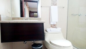 Un baño con inodoro, lavabo y ducha.