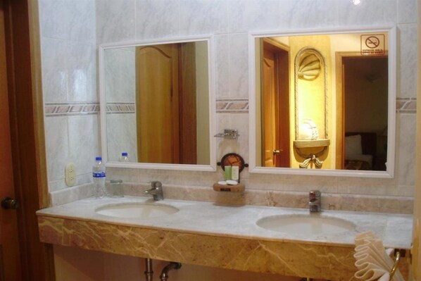 A bathroom with two sinks, a large mirror, and a towel rack.