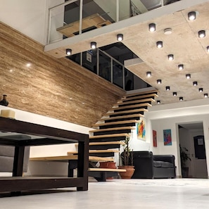 A modern interior with a wooden staircase, a seating area, and a ceiling with recessed lighting. - Hotel Libertador Pinamar (Pinamar)