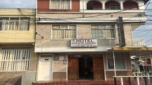 Un edificio de dos pisos con un cartel que indica que es un hotel llamado "Brisas de Granada".