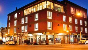 Un hotel de varios pisos con un restaurante en la planta baja y una entrada visible.