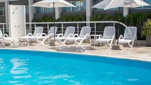 A swimming pool with white lounge chairs and umbrellas. - Maran Suites And Towers (Parana)