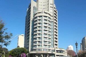 Un hotel alto con varios balcones y un letrero que dice "Qatar Hotel & Towers".