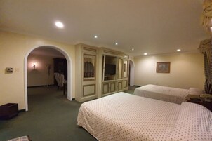 Habitación de hotel con dos camas, un espejo grande y un armario.