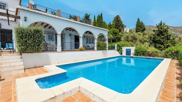 Relax by the serene pool surrounded by lush greenery and a tranquil atmosphere.