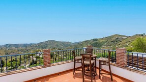Enjoy a serene view of rolling hills and a distant village from this outdoor space.