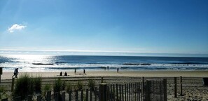 A beach with a wooden fence, people walking, and the ocean in the background. - Newly renovated- beautiful Condo near the Beach- Sleeps 4 Linen /Towels Provided (Ocean City)