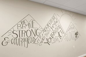 Una pared con texto motivacional y un dibujo de una bombilla.