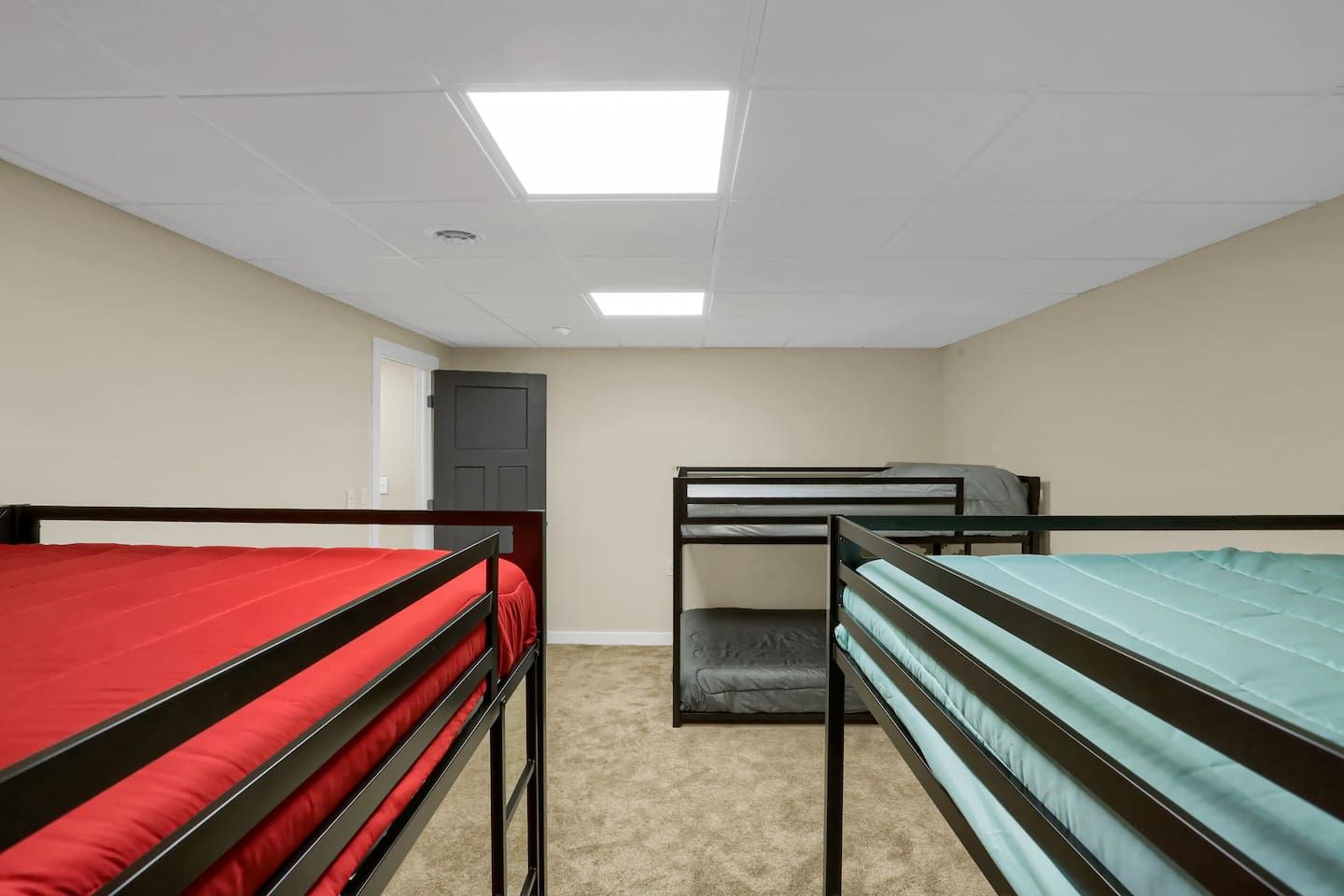 Un dormitorio con literas, una puerta y una lámpara en el techo.