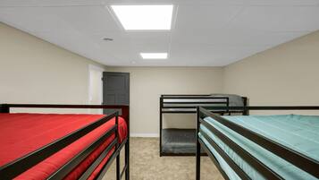 Un dormitorio con literas, una puerta y una lámpara en el techo.