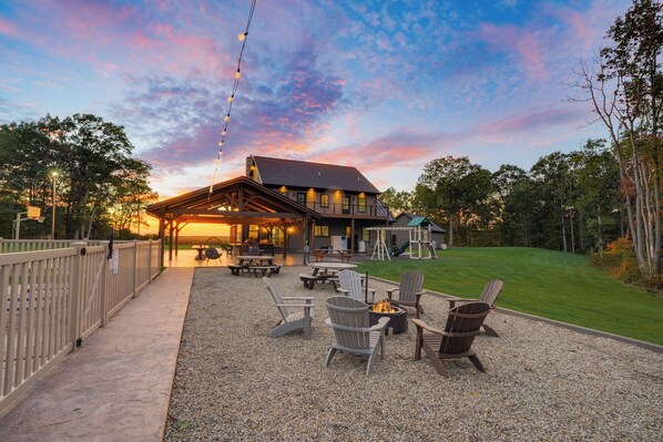 A lodge with a covered patio, outdoor seating, and a playground.