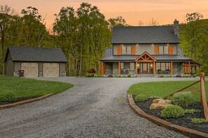 A two-story house with a covered porch and a garage.