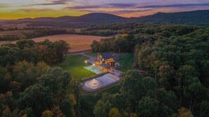 A large estate with a swimming pool, tennis court, and a well-maintained lawn.