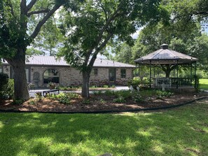A brick building with a covered pavilion in a landscaped garden. - Estate Home Overlooking The Vineyard (Santa Fe)