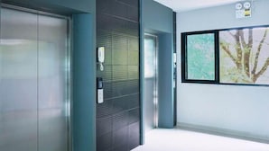 A modern elevator with a metallic finish and a textured wall panel. - Baan Pakdi (Pattaya)