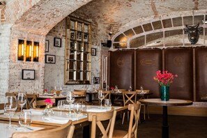 A restaurant with brick walls, wooden tables, and chairs. - Balthazar Design Hotel (Kraków)