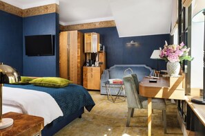 A hotel room with a bed, a desk with a lamp, a television, a wardrobe, and a coffee machine. - Balthazar Design Hotel (Kraków)