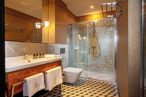 A modern bathroom with a glass-enclosed shower, a marble sink, and a checkered floor. - Balthazar Design Hotel (Kraków)