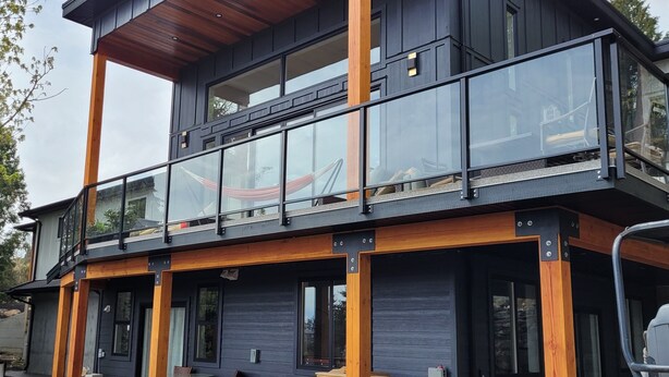A modern two-story house with a balcony, large windows, and a wooden deck. - PRIVATE Hot Tub with Valley Views!! (Colwood)