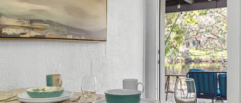 A dining area with a table set for two, featuring a bowl, cup, and glass.