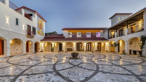 A courtyard with a tiled floor, stone arches, and a central fire feature. - A perfect destination for lovers of excellence and fine art (Spicewood)