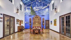 A spacious hallway with a polished floor, a dining area with a table and chairs, and a mural on the ceiling. - A perfect destination for lovers of excellence and fine art (Spicewood)