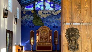 A spacious room with a high ceiling, a large wooden door, and a wall mural. - A perfect destination for lovers of excellence and fine art (Spicewood)