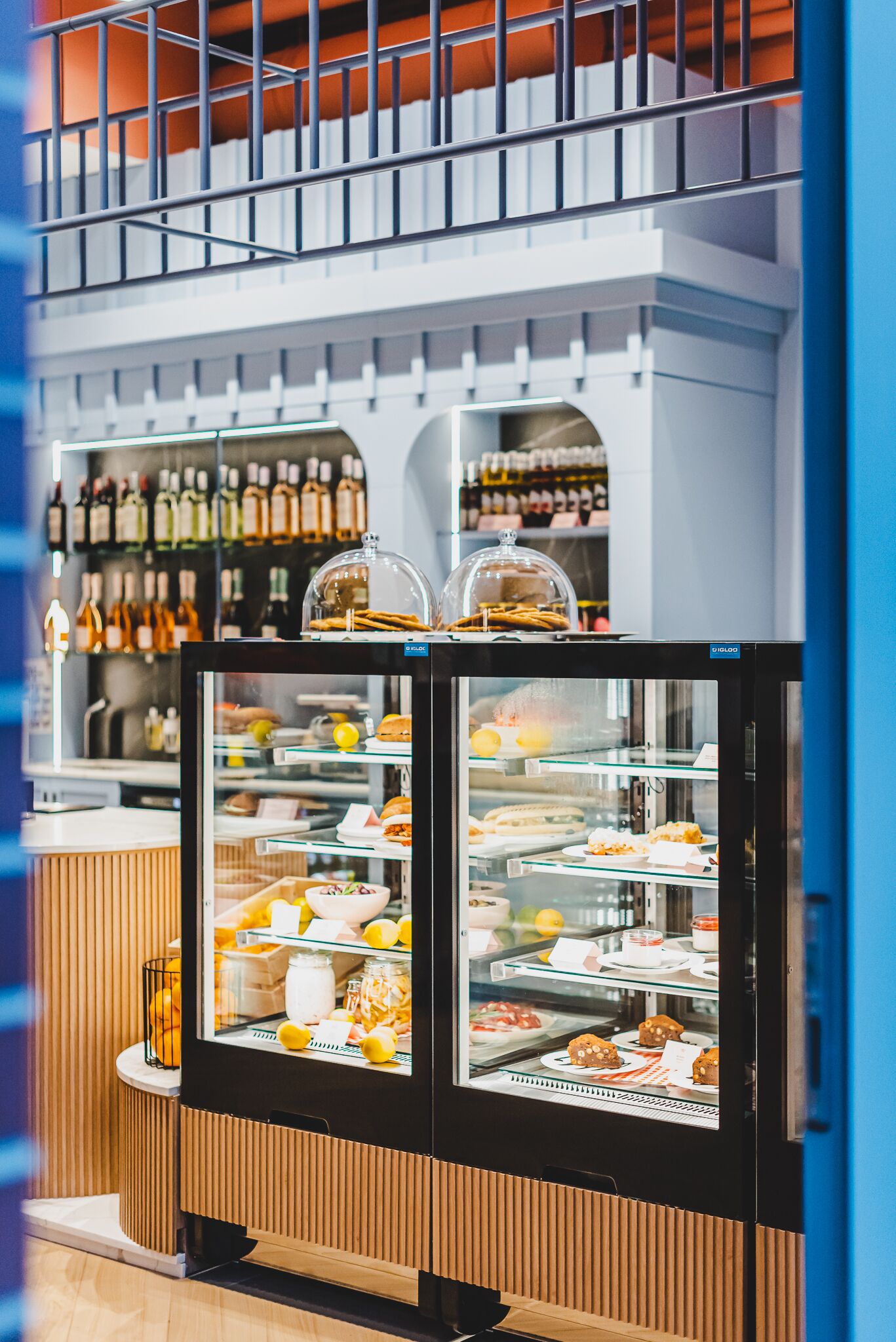A bakery display case with various baked goods and a selection of bottled beverages in the background.
